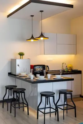 a kitchen with a counter with four bar stools at Mansion One l 5pax Studio l Seaview & Cityview l Georgetown l by PerfectSweetHome in George Town