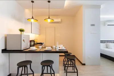 a kitchen and living room with a table and stools at Mansion One l 5pax Studio l Seaview & Cityview l Georgetown l by PerfectSweetHome in George Town