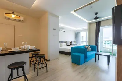 a living room with a blue couch and a bed at Mansion One l 5pax Studio l Seaview & Cityview l Georgetown l by PerfectSweetHome in George Town