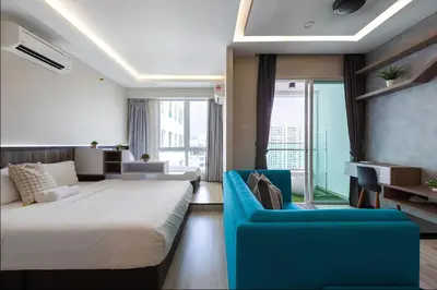 a bedroom with a large bed and a blue couch at Mansion One l 5pax Studio l Seaview & Cityview l Georgetown l by PerfectSweetHome in George Town