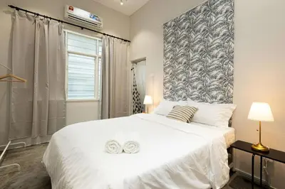 a bedroom with a large white bed with two towels on it at InWood - Pet allow Ipoh homestay & BBQ in Ipoh