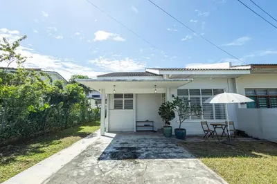 a white house with a table and an umbrella at InWood - Pet allow Ipoh homestay & BBQ in Ipoh