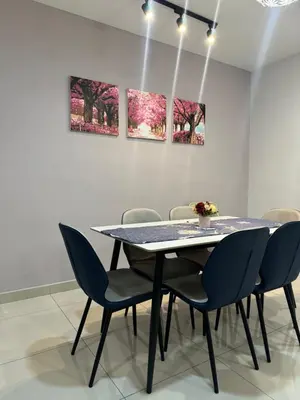 a table and chairs in a room with paintings at Premium Manhattan Ipoh \u6021\u4fdd\u6c11\u5bbf, 4bedroom 12pax, water park in Ipoh