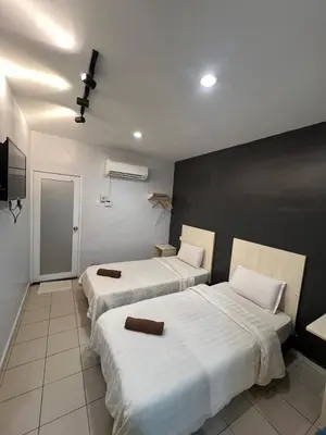 two beds in a hotel room with white sheets at Kangsar KK Hotel in Kuala Kangsar
