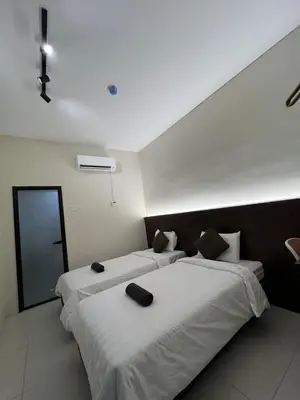 two beds in a hotel room with white sheets at Kangsar KK Hotel in Kuala Kangsar