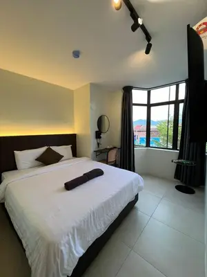 a bedroom with a large white bed and a window at Kangsar KK Hotel in Kuala Kangsar
