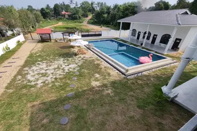a swimming pool with a pink flamingo next to a house at Grand Aeden Villa in Kuala Kangsar