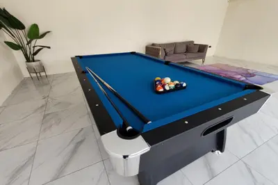 a pool table in a living room with a pool at Grand Aeden Villa in Kuala Kangsar
