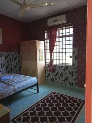 a bedroom with a bed and a window and a rug at Homestay Mariah in Ipoh