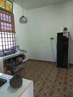 a kitchen with a black refrigerator in a room at Homestay Mariah in Ipoh
