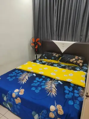 a bed with a yellow and blue comforter on it at Mateen Cottage II in Tanah Rata