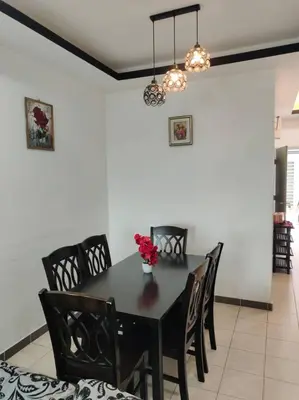 a dining room with a black table and chairs at Mateen Cottage II in Tanah Rata