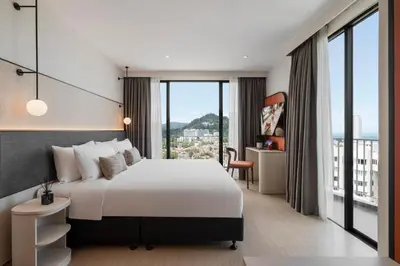 a hotel room with a bed and a large window at Citadines Tanjung Tokong Penang in George Town
