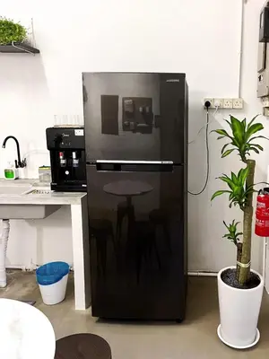 a refrigerator with a table in it in a kitchen at Pine Armenian in George Town