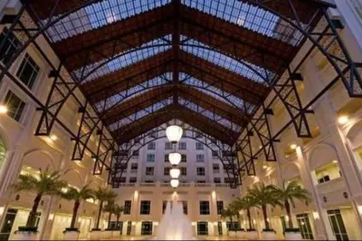 a large building with a large ceiling with palm trees at 2 bedroom Suite with Sea View At Straits Quay in Tanjong Tokong