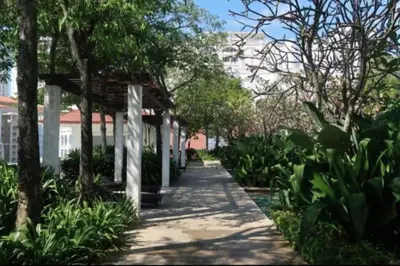 a walkway through a garden with trees and a building at 2 bedroom Suite with Sea View At Straits Quay in Tanjong Tokong