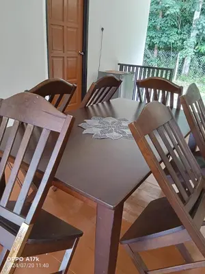 a wooden table with chairs and a table cloth on it at Bilik Naqiah in Gerik