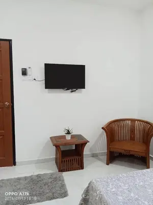 a living room with a tv on a wall at Bilik Naqiah in Gerik