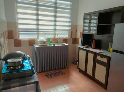 a kitchen with a stove and a sink at Fatimah HomeStay Kulim Hi Tech in Kulim