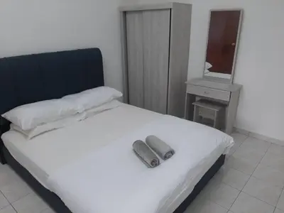 a bedroom with a white bed with a phone on it at Fatimah HomeStay Kulim Hi Tech in Kulim