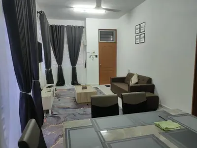 a living room with a couch and a table and chairs at Fatimah HomeStay Kulim Hi Tech in Kulim