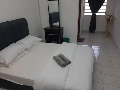 a bedroom with a white bed with a towel on it at Fatimah HomeStay Kulim Hi Tech in Kulim