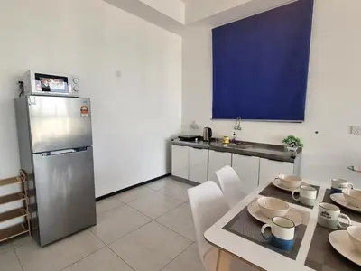 a kitchen with a stainless steel refrigerator and a table at Skyblue 2 Rooms Apartment, 4 plus 2 Pax at Urban Suites in Jelutong