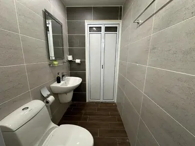 a bathroom with a white toilet and a sink at Landed House Gelugor 5BR 3B-20pax by 3C in Gelugor