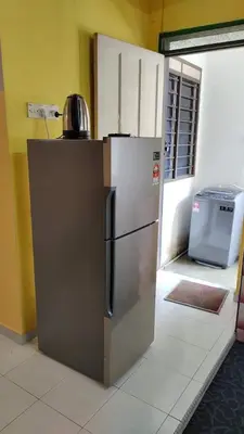 a stainless steel refrigerator sitting in a room at RS Homestay Gerik in Gerik