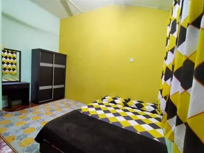 a bedroom with a bed and a yellow wall at RS Homestay Gerik in Gerik
