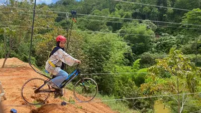 a man riding a bike on a zip line at RS Homestay Gerik in Gerik