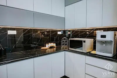 a kitchen with white cabinets and a microwave oven at Ipoh Mansion House 25 by Verve in Ipoh