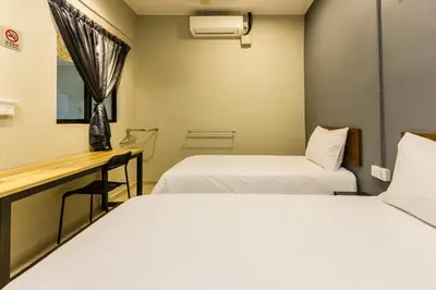 a room with two beds and a desk at Urban 10pax Terrace Gem near Sunway Carnival in Perai