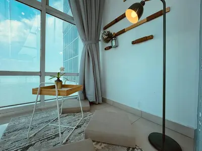a room with a table and a lamp and a window at NEW - Panorama Komtar SeaView Meritime Suites in Jelutong