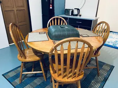 a wooden table with chairs and a green bag on it at Inap Desa R'Sawit Pintu B in Sekincan