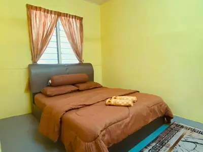 a small bedroom with a bed with a window at Inap Desa R'Sawit - A dan B in Sekincan
