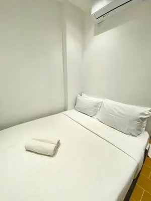 a white bed with a napkin on top of it at The 6N by Sky Hive in George Town
