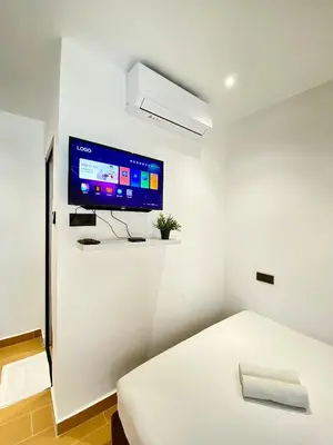 a room with a bed and a tv on a wall at The 6N by Sky Hive in George Town