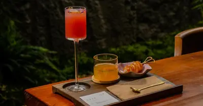 a drink in a glass sitting on a wooden table at Zen By Stellar Cameron in Brinchang