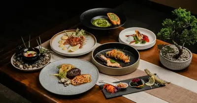 a wooden table with plates of food on it at Zen By Stellar Cameron in Brinchang
