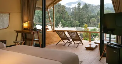 a bedroom with a bed and a desk and a balcony at Zen By Stellar Cameron in Brinchang