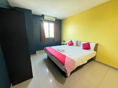 a bedroom with a bed with red and yellow walls at Hotel Pinji Ipoh in Ipoh