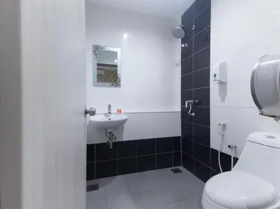 a bathroom with a white toilet and a sink at Hotel Pinji Ipoh in Ipoh
