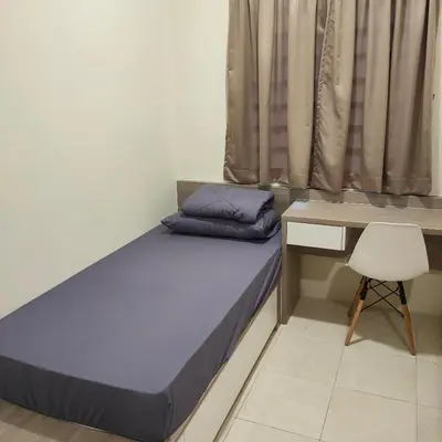 a bed in a room with a desk and a chair at Mimms Homestay Teluk Intan in Teluk Intan