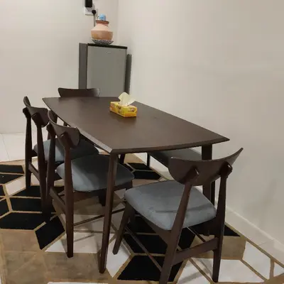 a wooden table with four chairs and a box of tissues at Mimms Homestay Teluk Intan in Teluk Intan