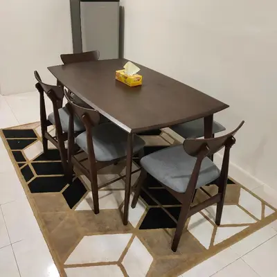 a wooden table with chairs and a box of tissues at Mimms Homestay Teluk Intan in Teluk Intan