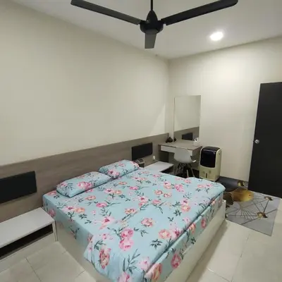 a bedroom with a bed and a desk in it at Mimms Homestay Teluk Intan in Teluk Intan