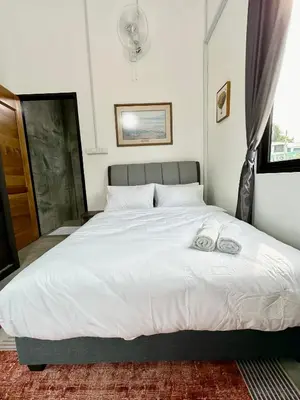 a bedroom with a large white bed with two towels on it at Ferringhi Inn 51 in Batu Ferringhi