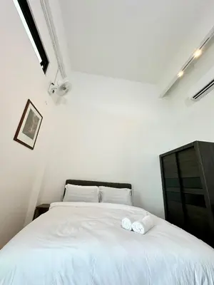 a bedroom with a white bed with two pillows at Ferringhi Inn 51 in Batu Ferringhi