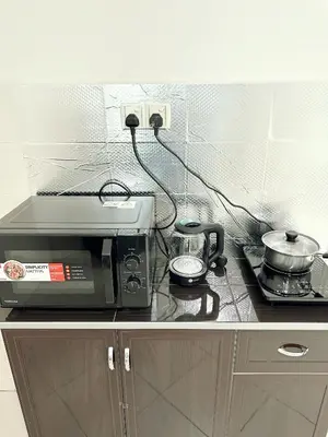 a microwave sitting on top of a kitchen counter at Tur16 SPlCE 10pax 4room Private House in Bayan Lepas